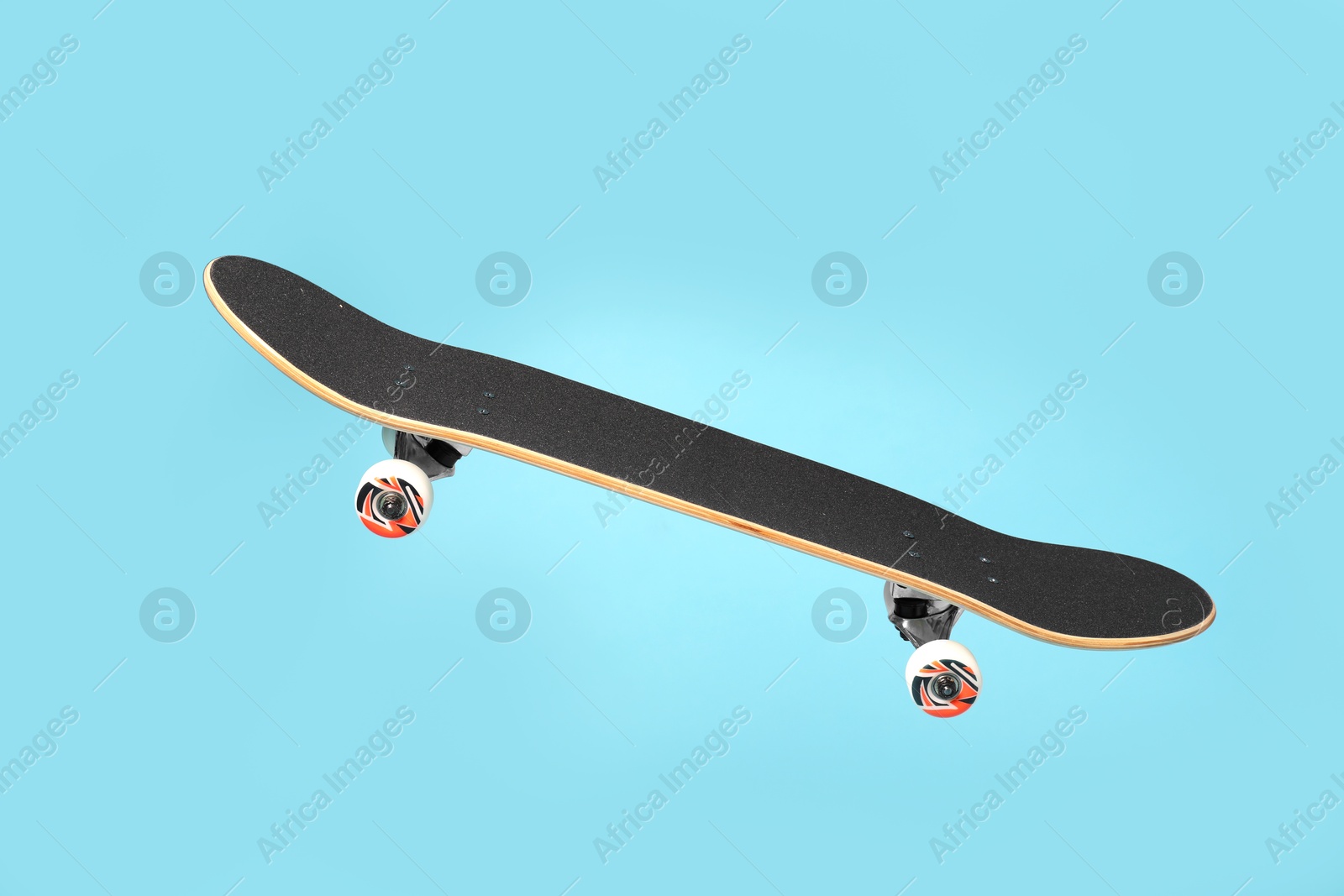 Photo of One skateboard on light blue background. Sports equipment