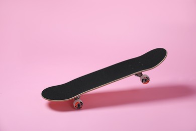 Photo of One skateboard on pink background. Sports equipment