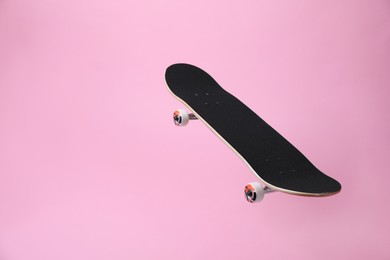 Photo of One skateboard on pink background, space for text. Sports equipment