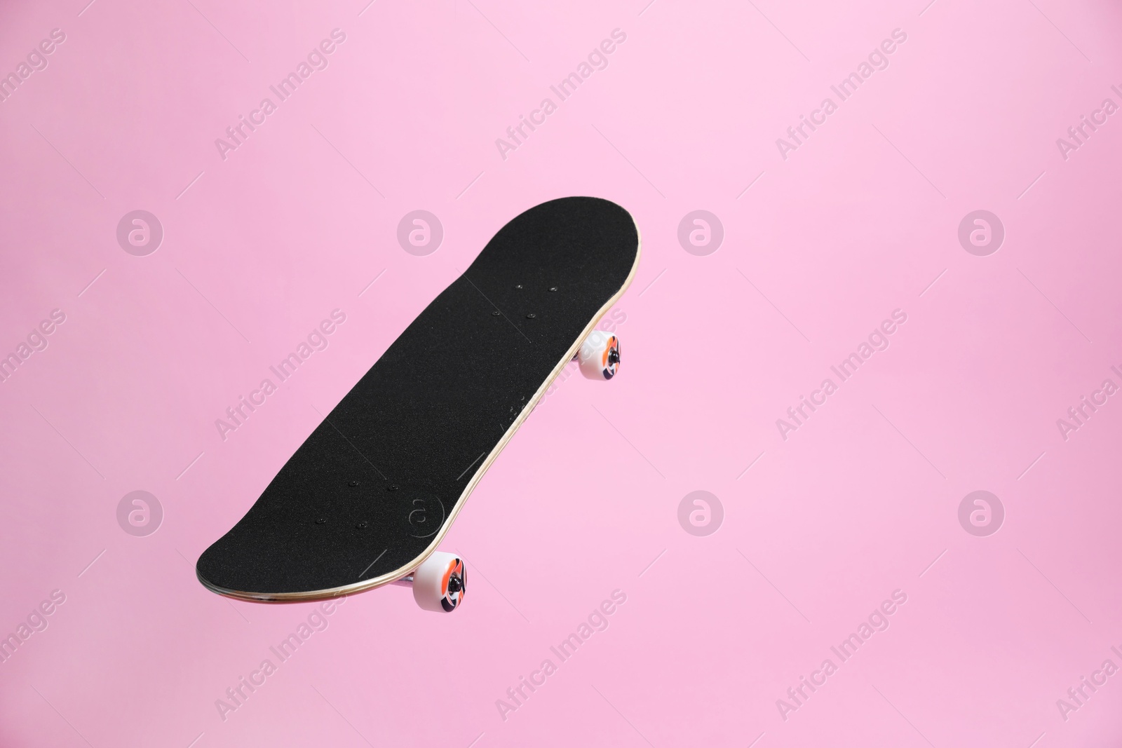 Photo of One skateboard on pink background, space for text. Sports equipment