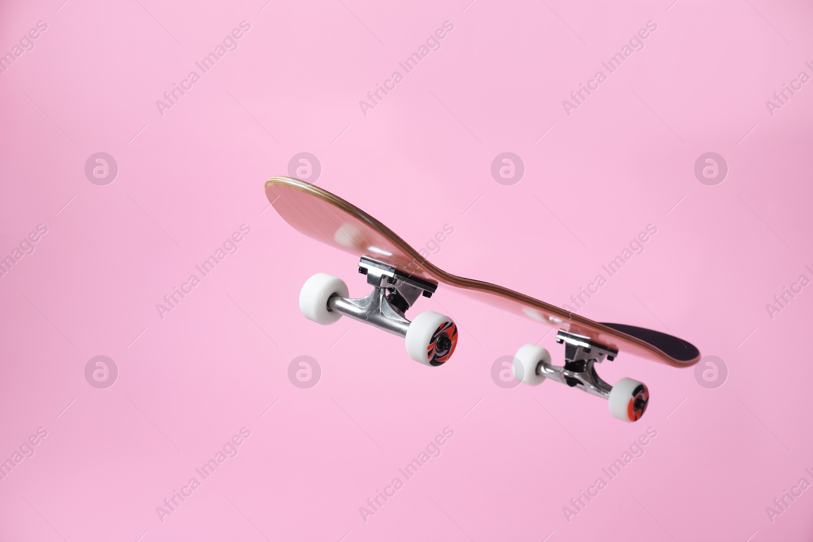 Photo of One skateboard on pink background. Sports equipment