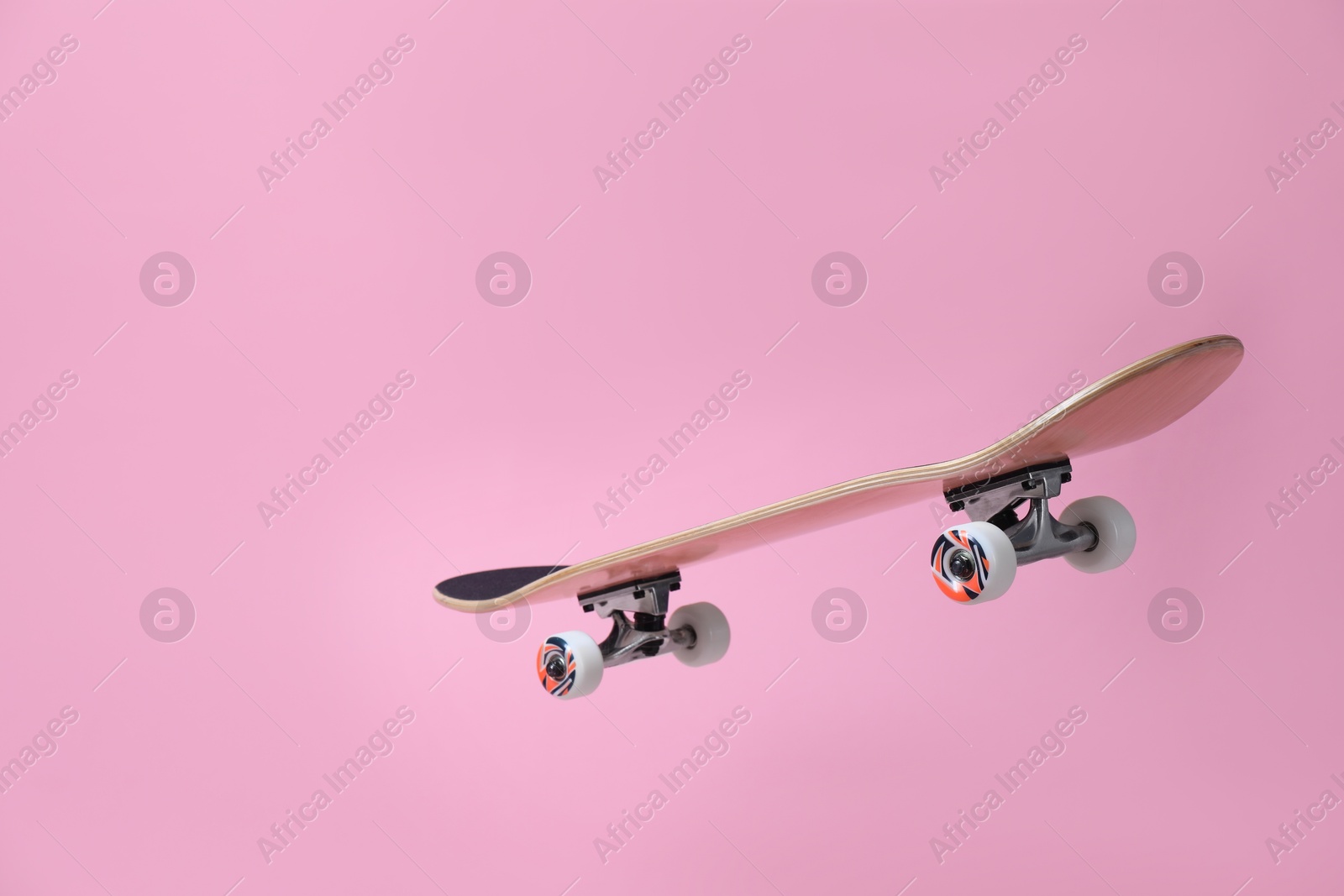 Photo of One skateboard on pink background. Sports equipment