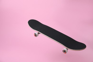 Photo of One skateboard on pink background. Sports equipment