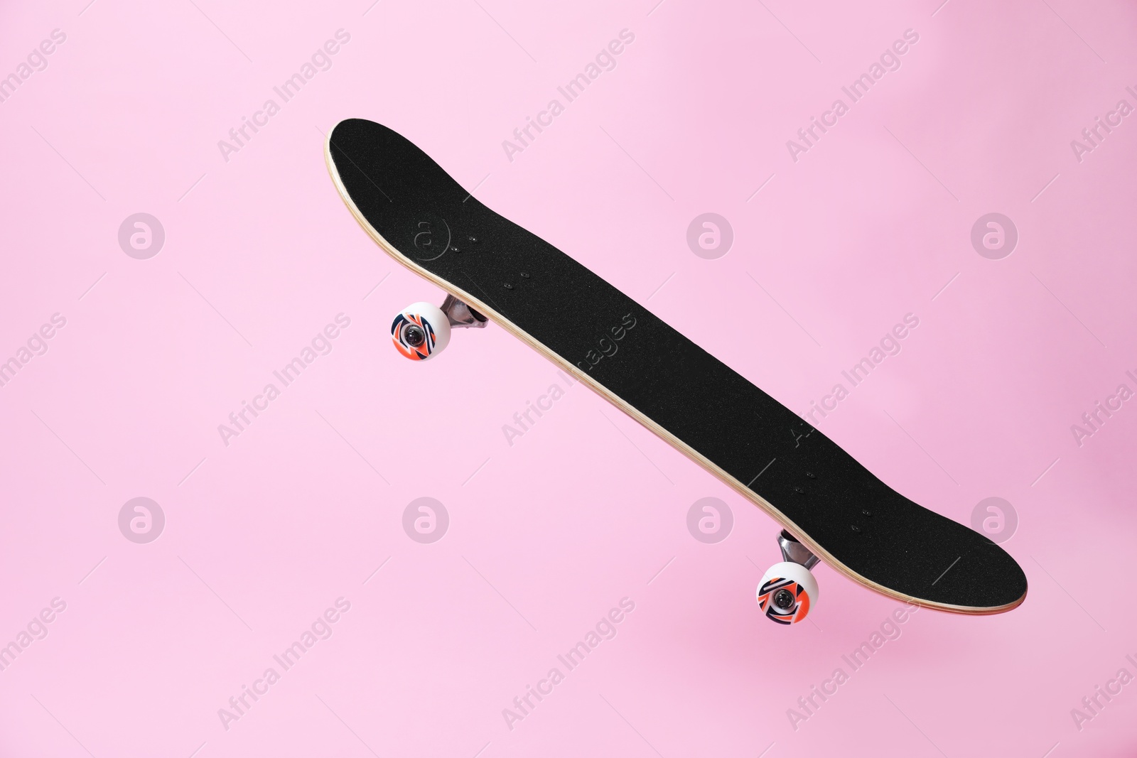 Photo of One skateboard on pink background. Sports equipment