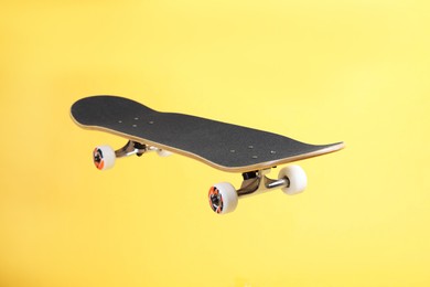 Photo of One skateboard on yellow background. Sports equipment