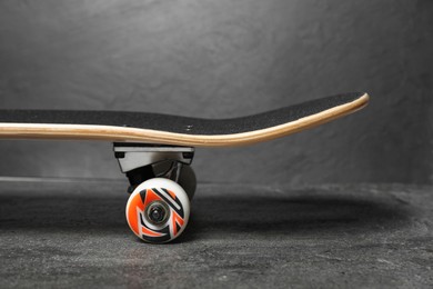 Photo of One modern skateboard on grey surface, closeup