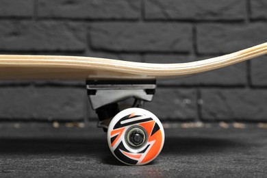 Photo of One modern skateboard on grey surface, closeup