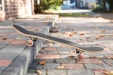 Photo of One modern skateboard on paved pathway outdoors