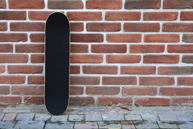 Photo of One skateboard near brick wall outdoors, space for text