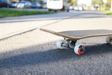 Photo of One modern skateboard on ground outdoors, closeup