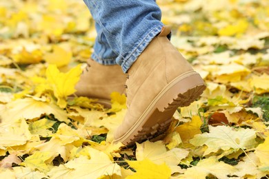 Photo of Man walking on grass with fallen leaves, closeup