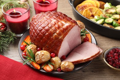 Photo of Christmas food. Tasty baked ham served on wooden table, closeup