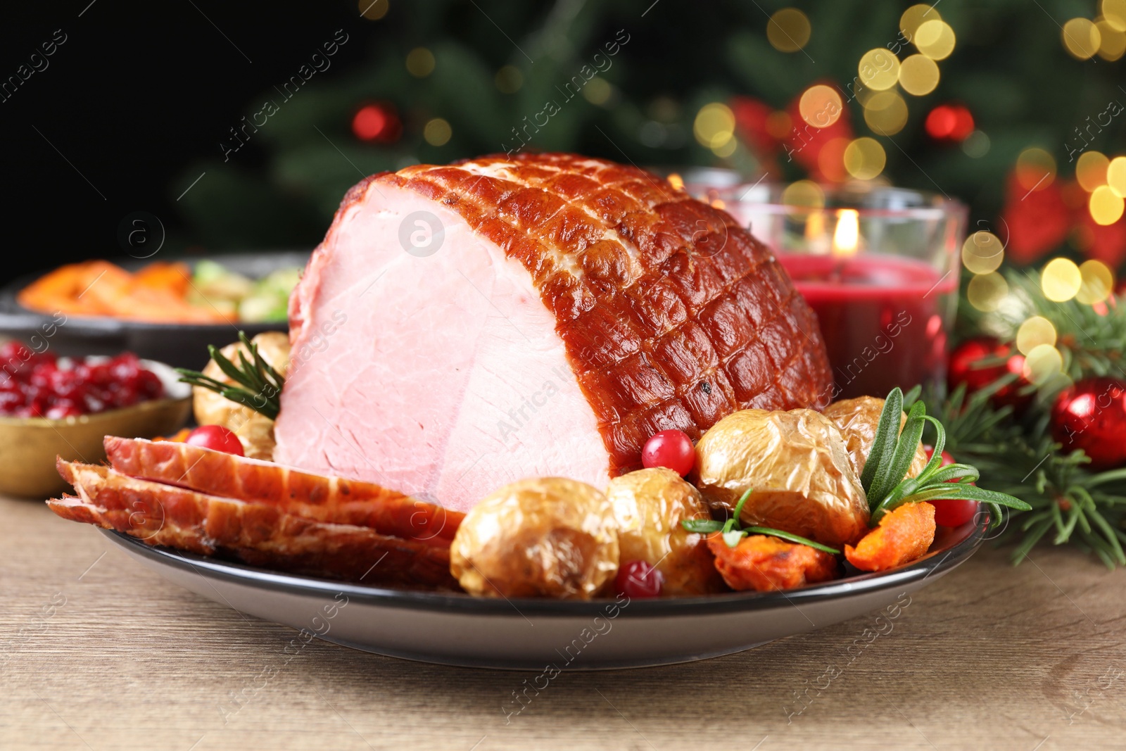 Photo of Christmas food. Tasty baked ham served on wooden table, closeup