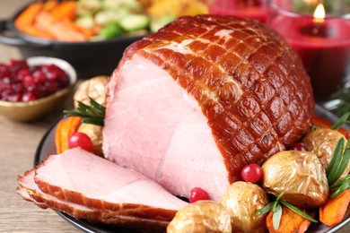 Photo of Christmas food. Tasty baked ham served on wooden table, closeup