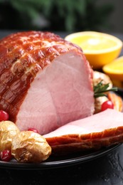 Photo of Christmas food. Tasty baked ham served on black table, closeup