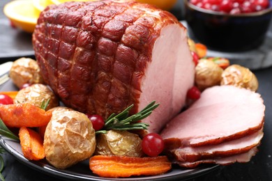 Photo of Christmas food. Tasty baked ham served on black table, closeup