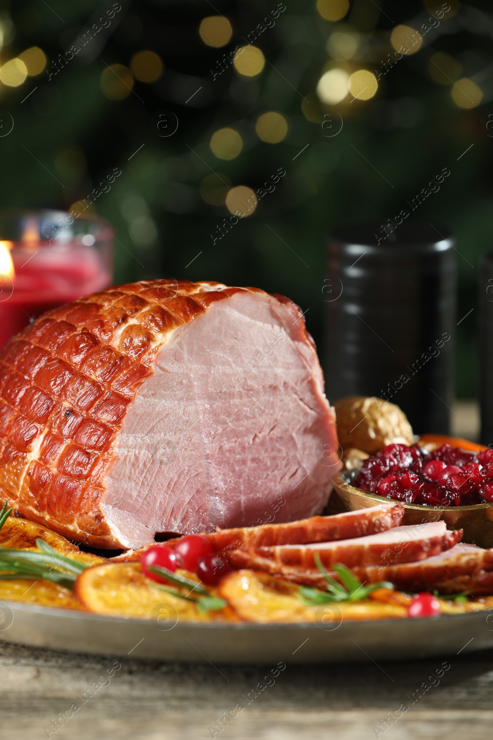 Photo of Christmas food. Tasty baked ham served on wooden table, closeup