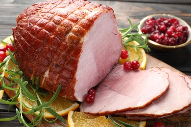 Photo of Christmas food. Tasty baked ham served on wooden table, closeup