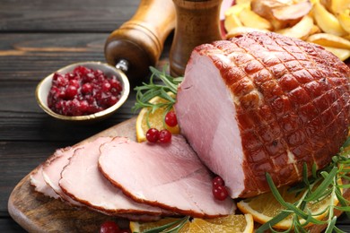 Photo of Christmas food. Tasty baked ham served on wooden table, closeup