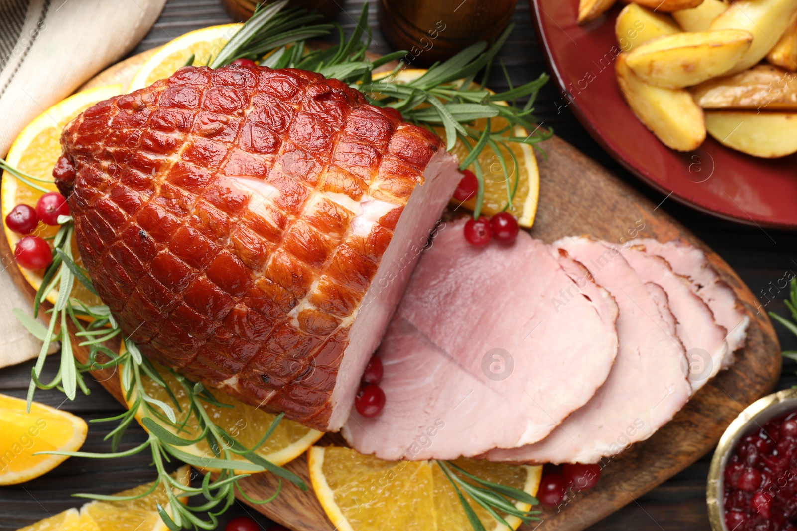 Photo of Christmas food. Tasty baked ham served on wooden table, flat lay