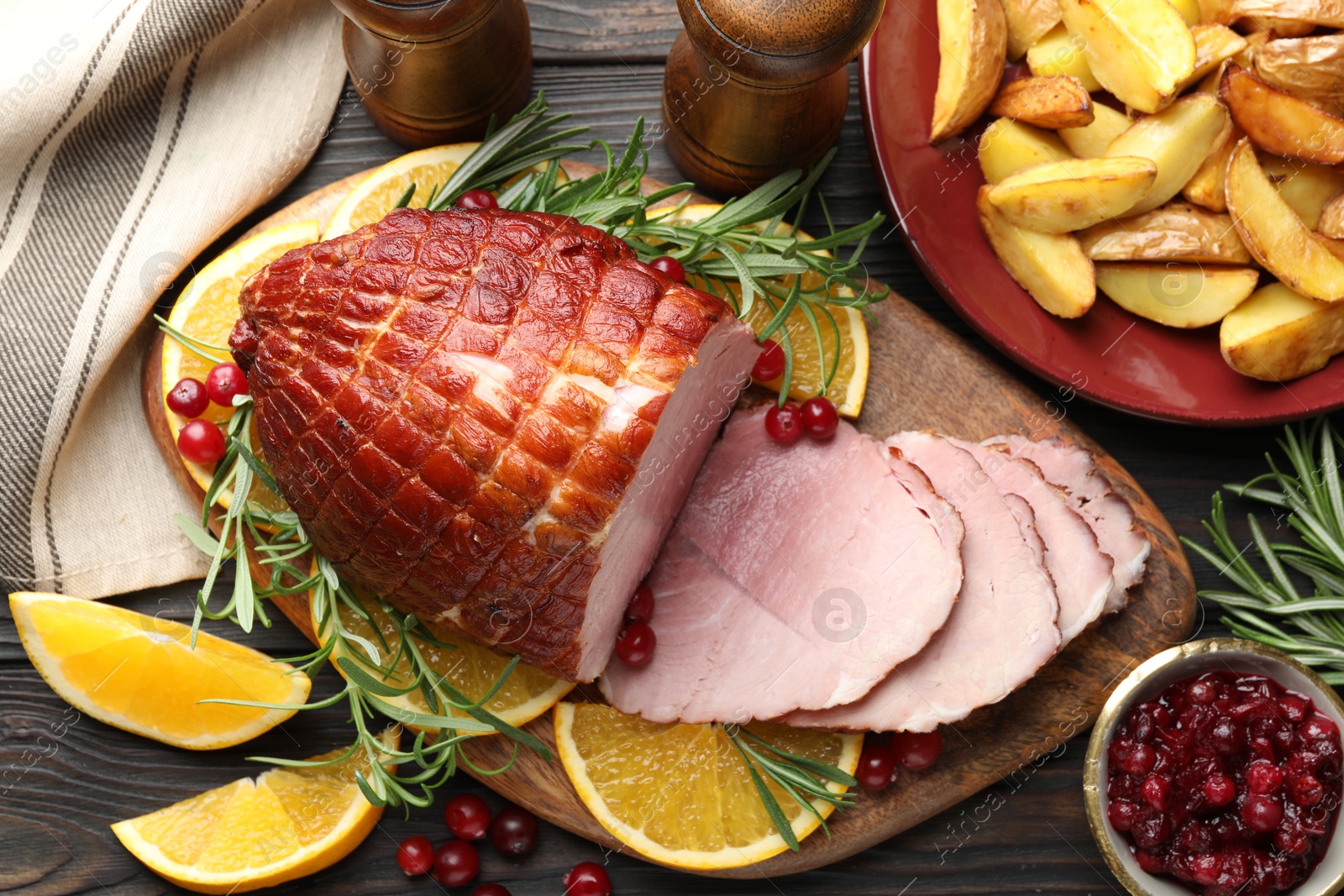 Photo of Christmas food. Tasty baked ham served on wooden table, flat lay