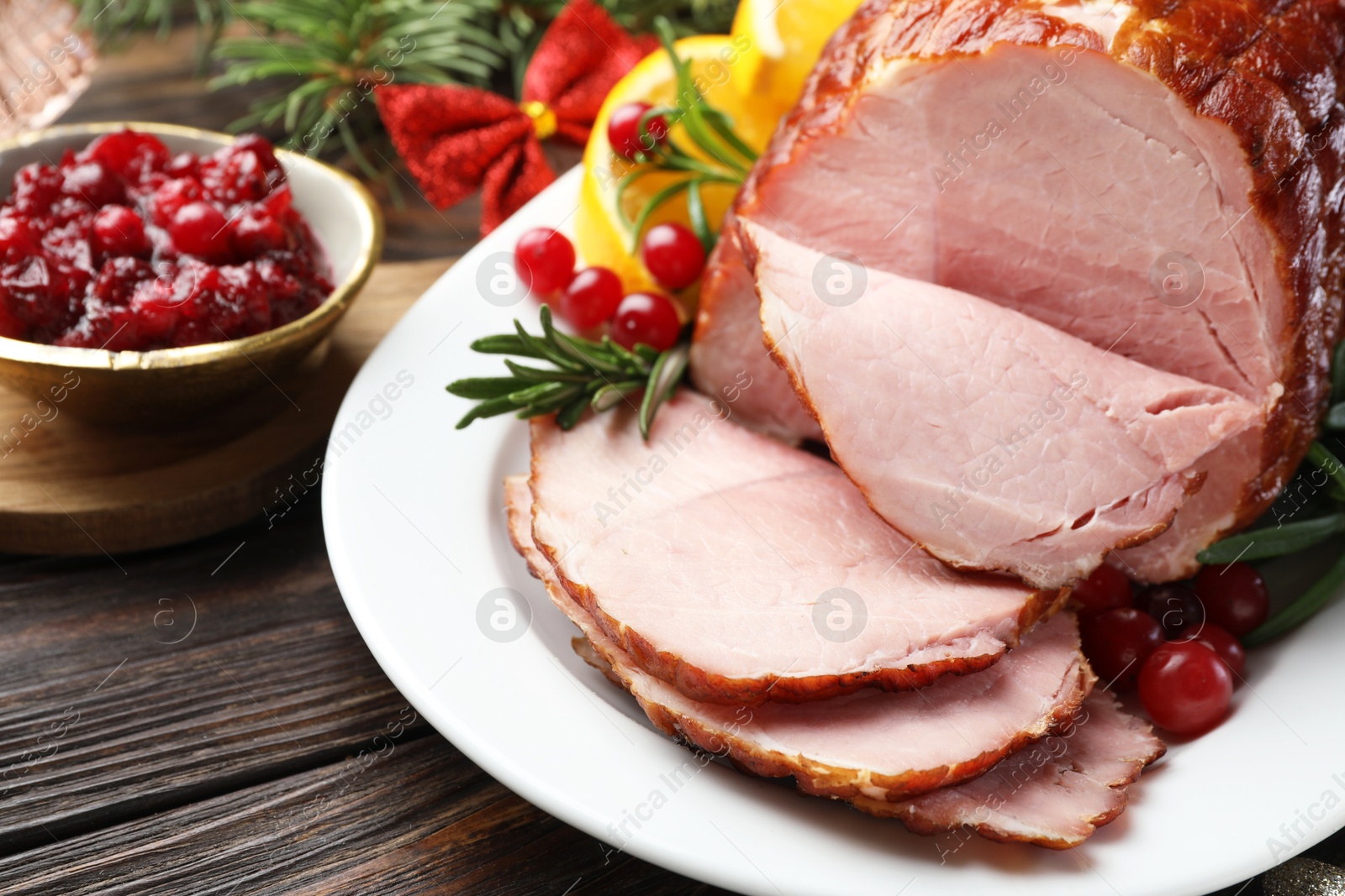 Photo of Christmas food. Tasty baked ham served on wooden table, closeup