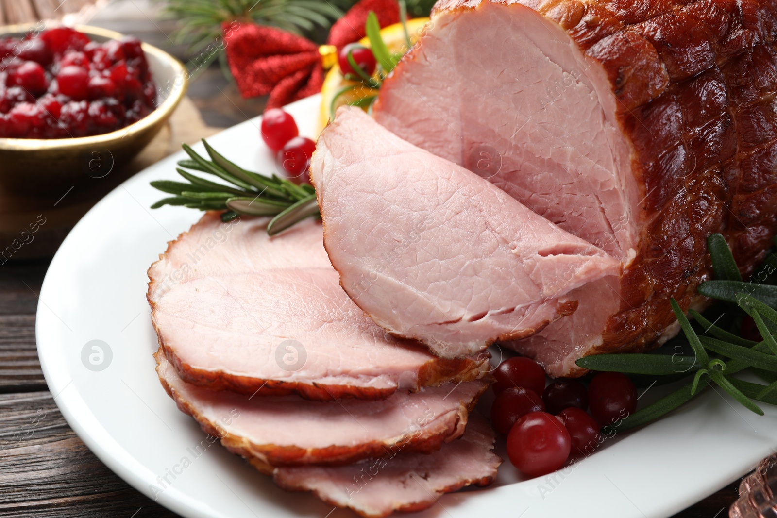 Photo of Christmas food. Tasty baked ham served on wooden table, closeup