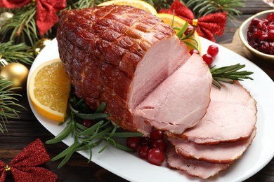 Photo of Christmas food. Tasty baked ham served on wooden table, closeup