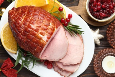 Photo of Christmas food. Tasty baked ham served on wooden table, flat lay