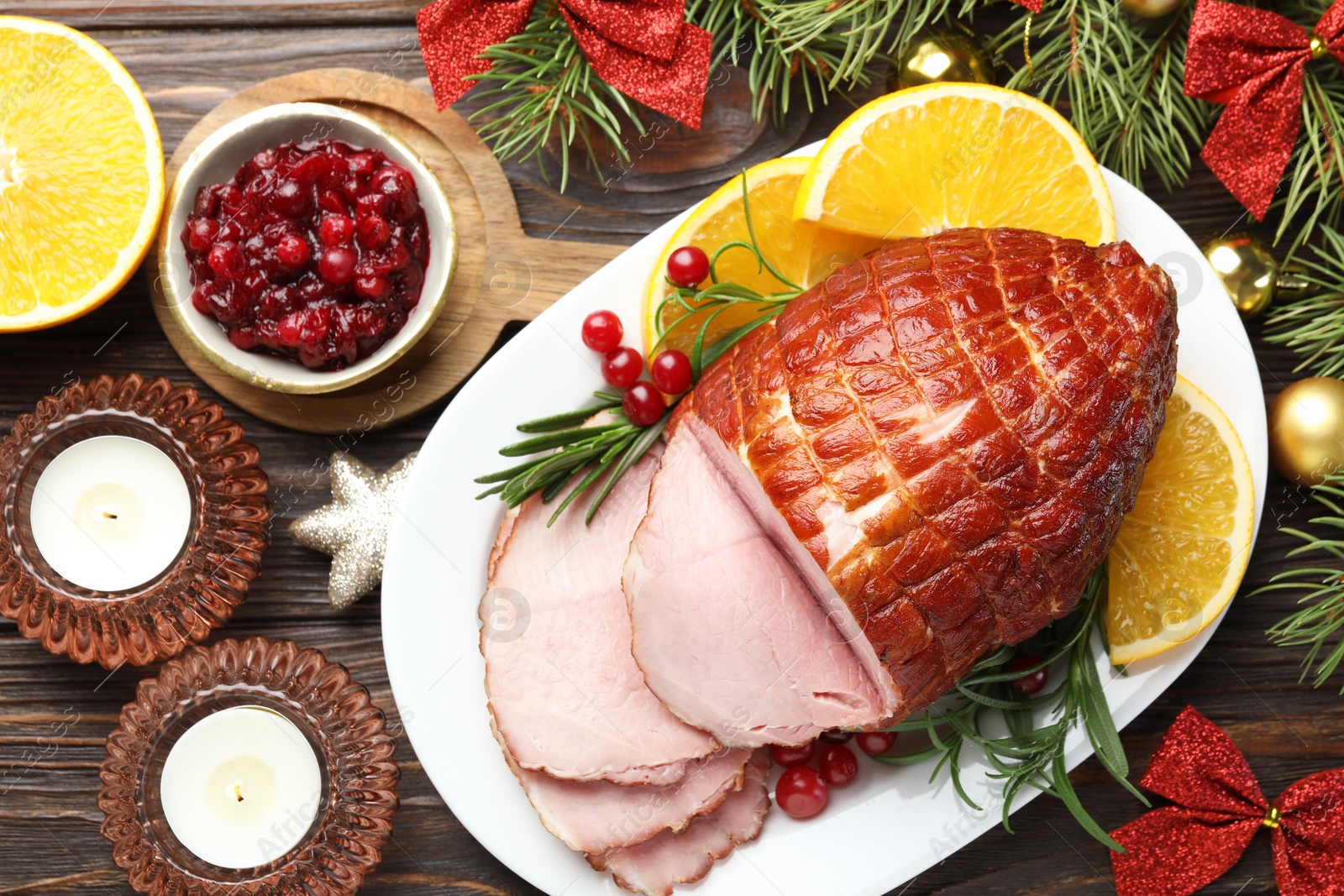 Photo of Christmas food. Tasty baked ham served on wooden table, flat lay