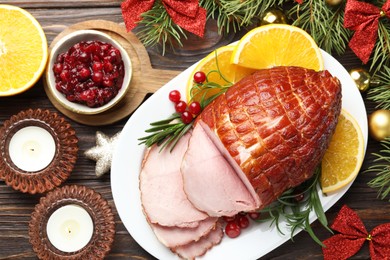 Photo of Christmas food. Tasty baked ham served on wooden table, flat lay