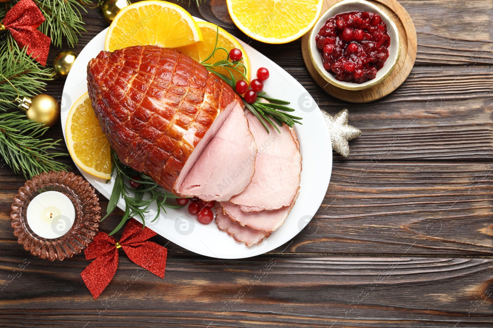 Photo of Christmas food. Tasty baked ham served on wooden table, flat lay