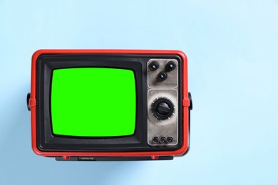 Image of Retro Tv set with green screen on light blue background, space for design. Chroma key