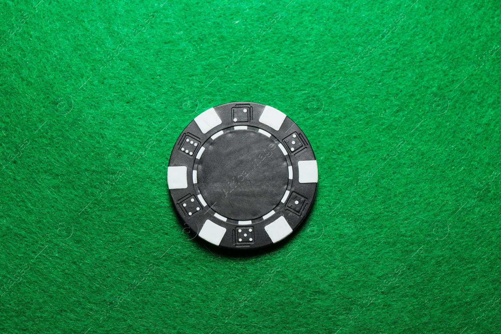 Photo of Poker chip on green table, top view