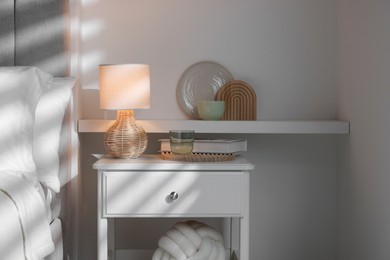 Photo of Stylish living room interior with bed, bedside table and lamp