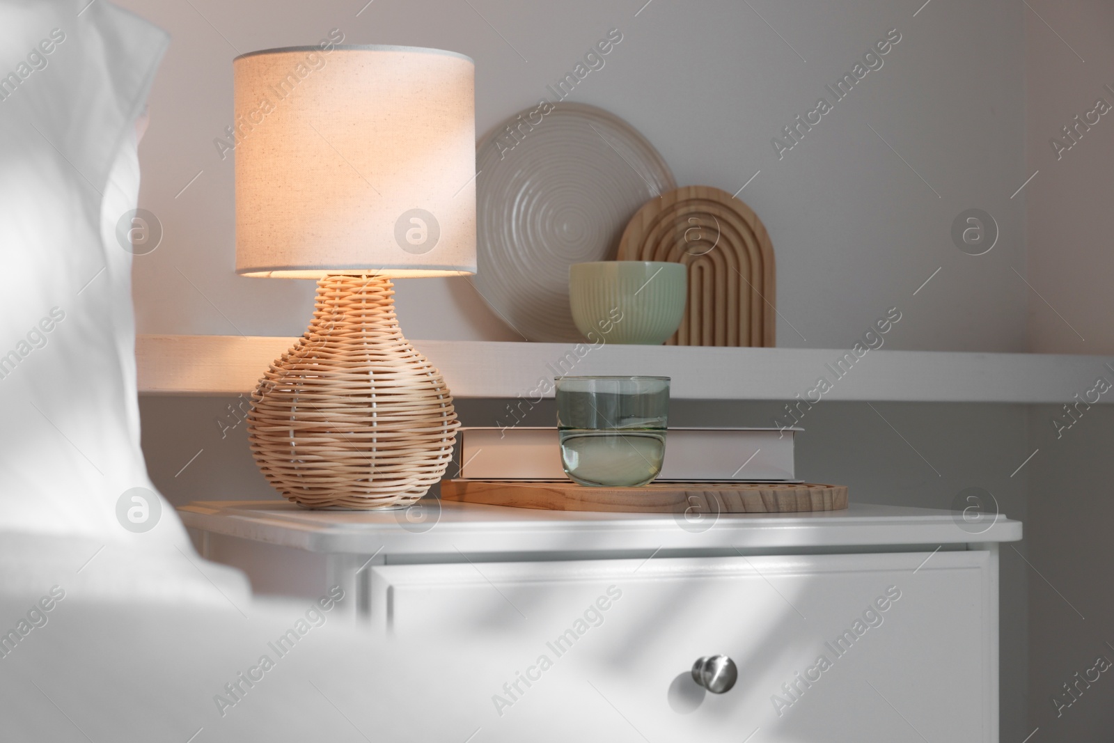 Photo of Stylish living room interior with bed, bedside table and lamp