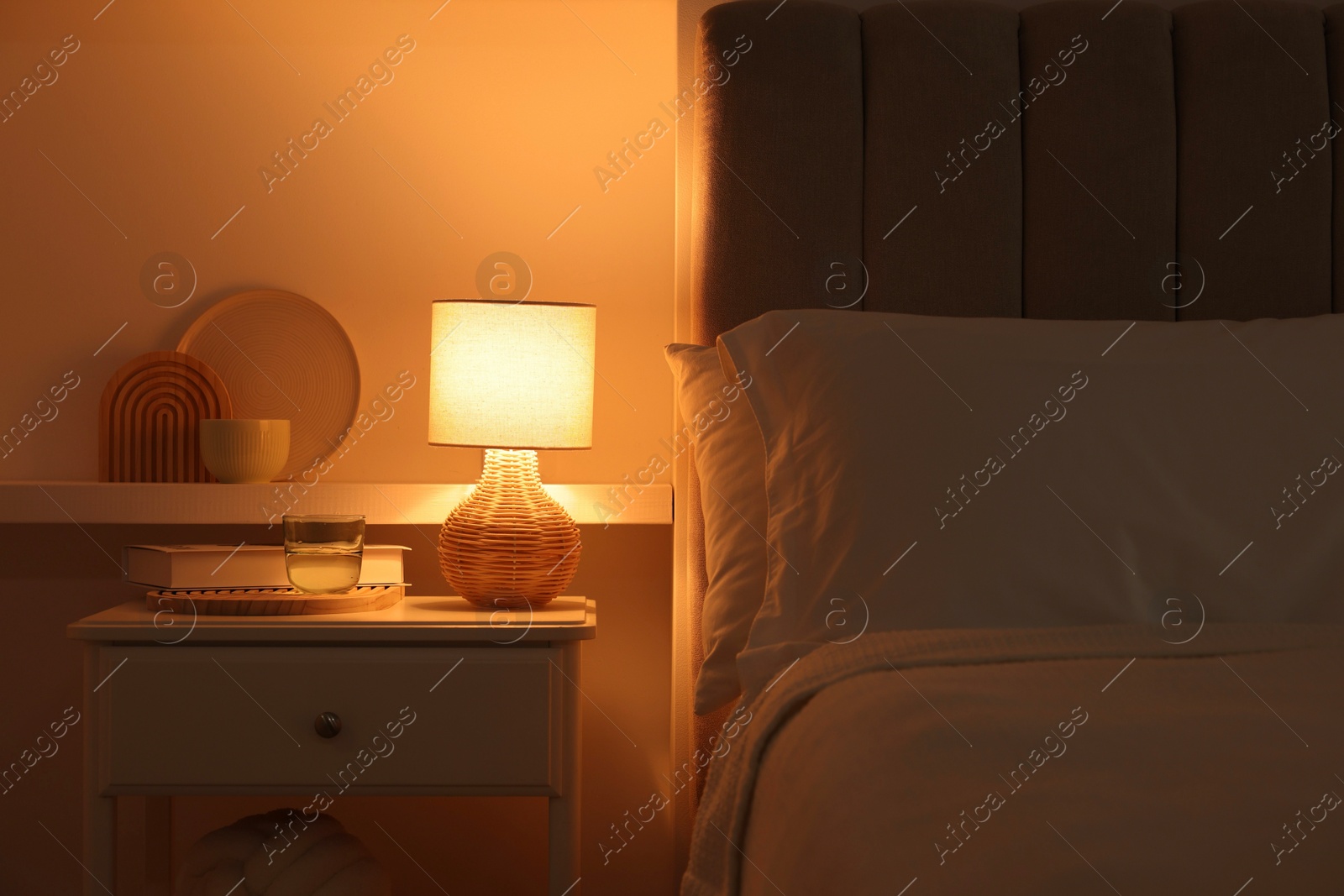 Photo of Stylish living room interior with bed, bedside table and lamp