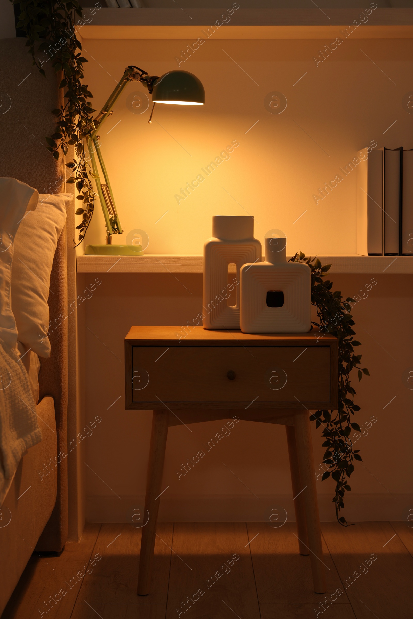 Photo of Stylish living room interior with bed, bedside table and lamp