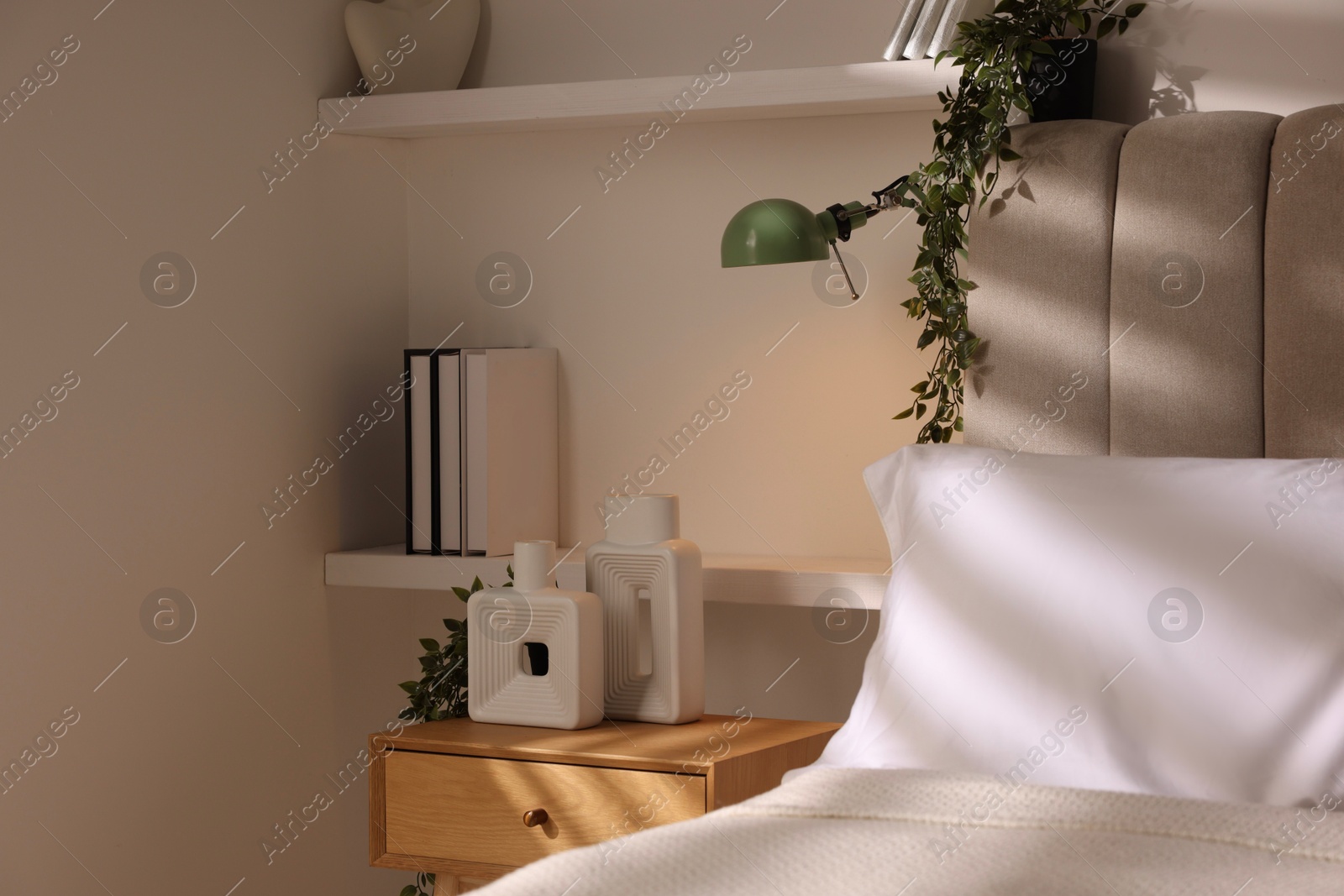 Photo of Stylish living room interior with bed, bedside table and lamp