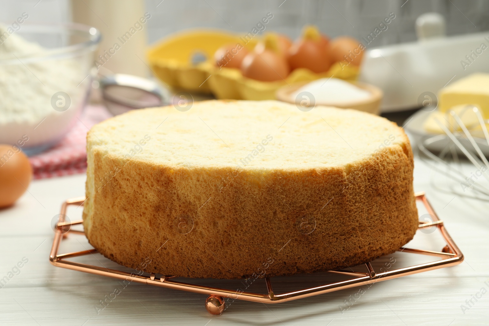 Photo of Tasty cut sponge cake on white wooden table, closeup