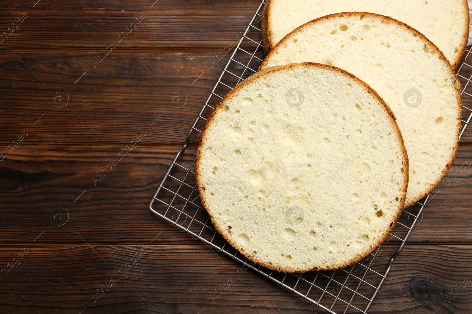 Photo of Delicious cut sponge cake on wooden table, flat lay. Space for text