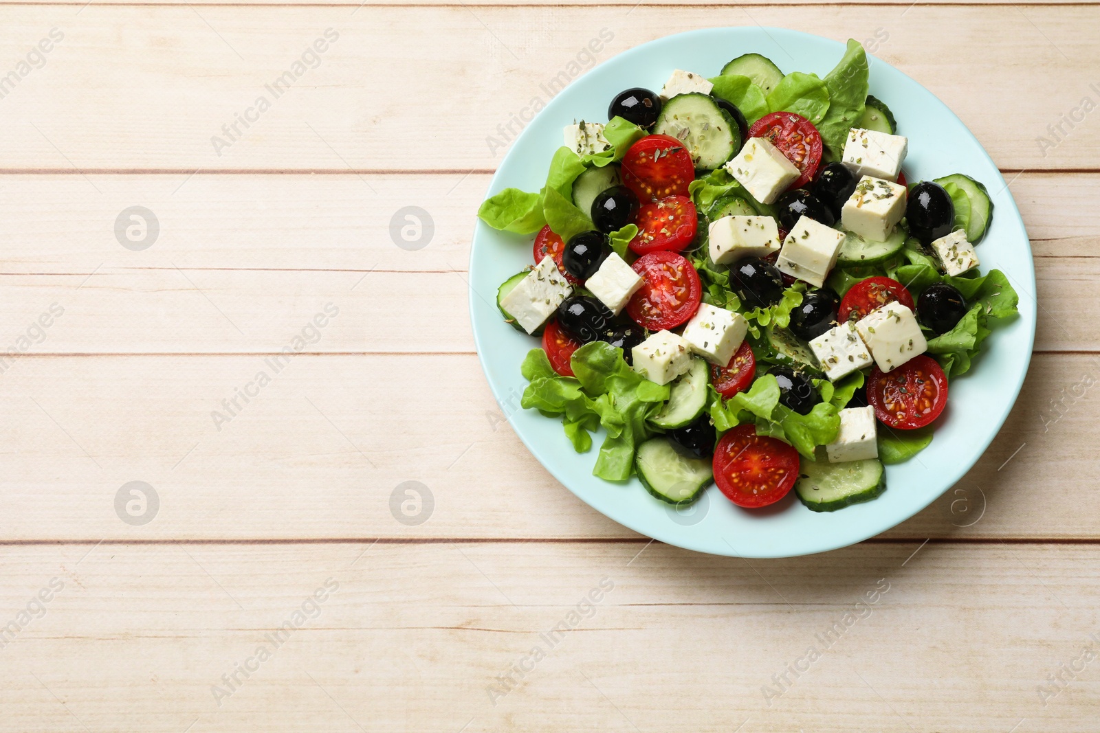 Photo of Delicious salad with feta cheese on white wooden table, top view. Space for text