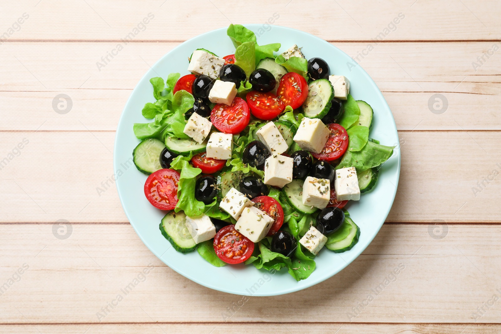 Photo of Delicious salad with feta cheese on white wooden table, top view