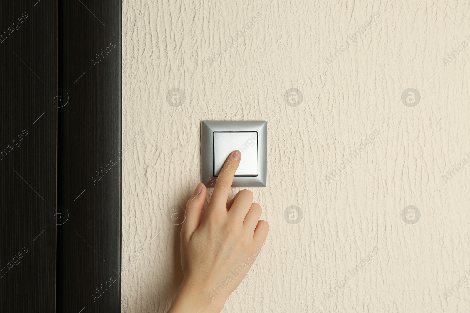 Photo of Woman turning light switch on, closeup view