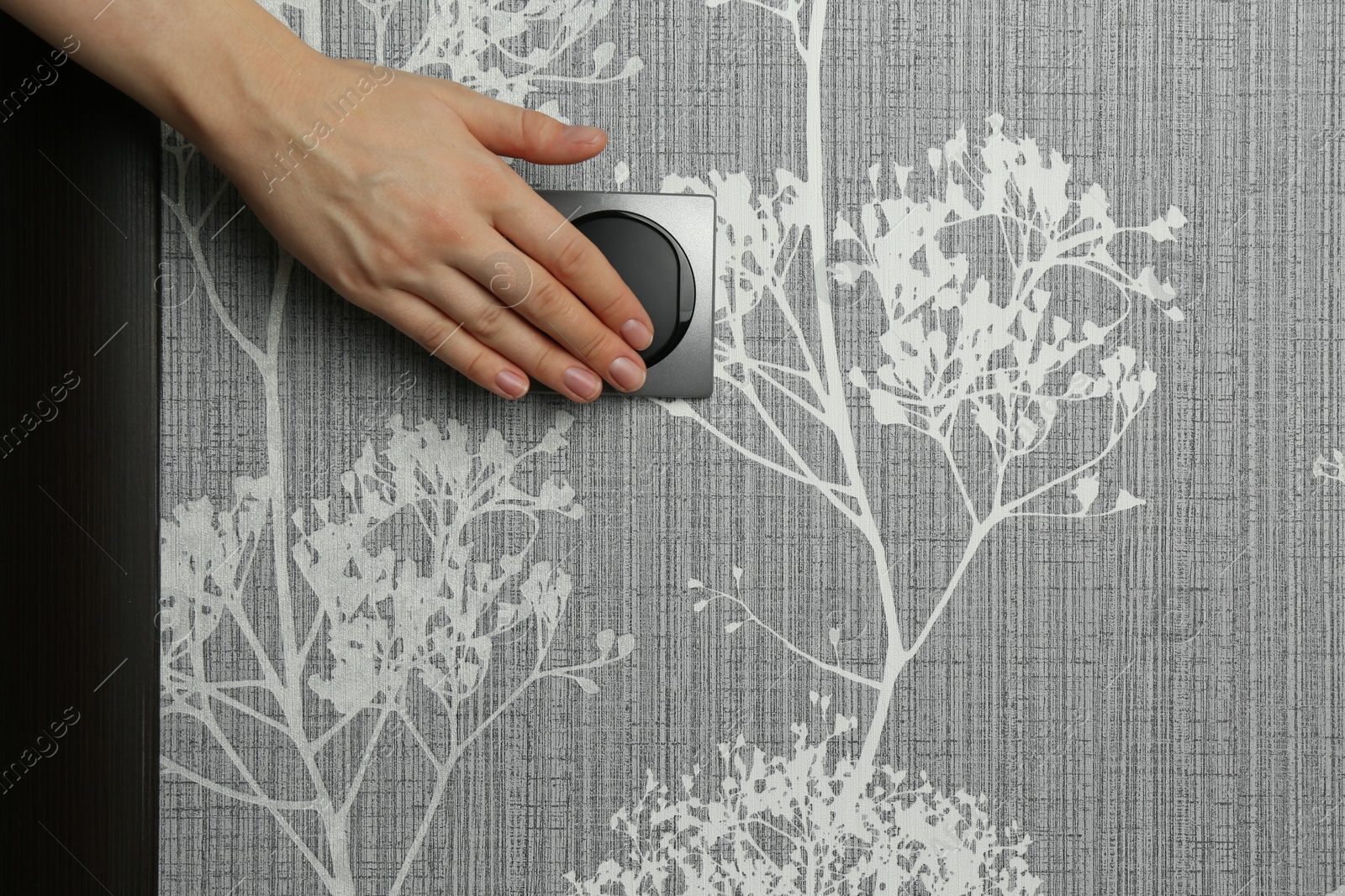 Photo of Woman turning light switch on, closeup view