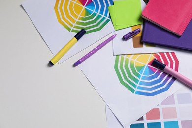 Photo of Designer's workplace with different palettes and stationery on white table, flat lay. Space for text