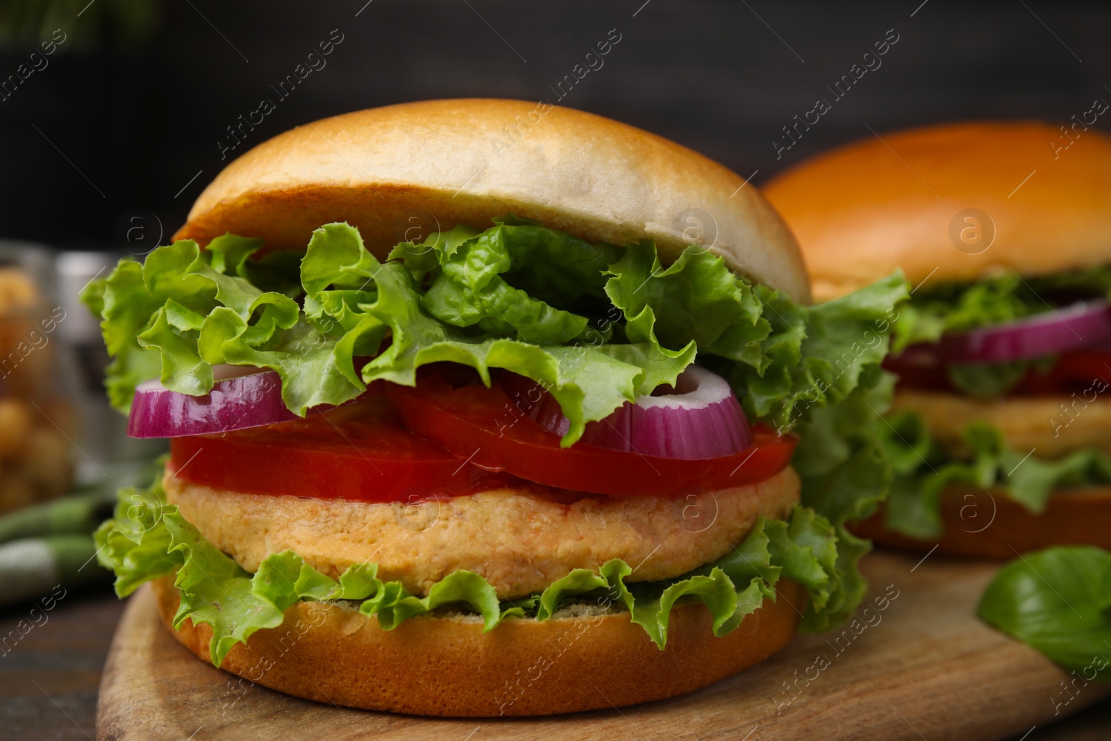 Photo of Delicious vegetarian burgers with chickpea cutlets on wooden table, closeup