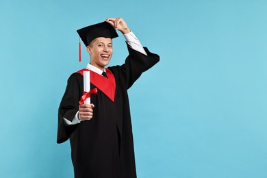 Photo of Happy student with diploma after graduation on light blue background. Space for text