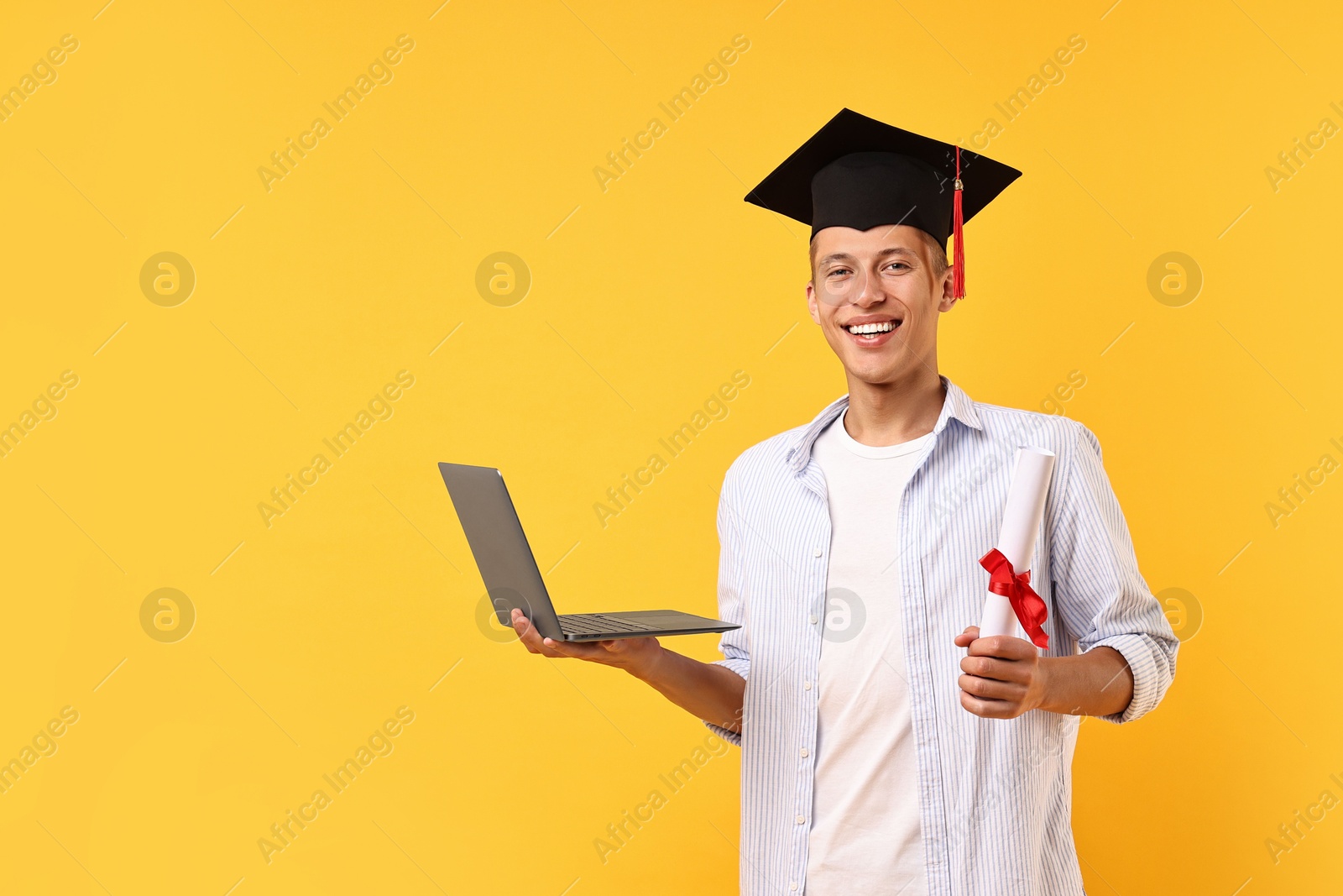 Photo of Happy student with diploma and laptop after graduation on orange background. Space for text