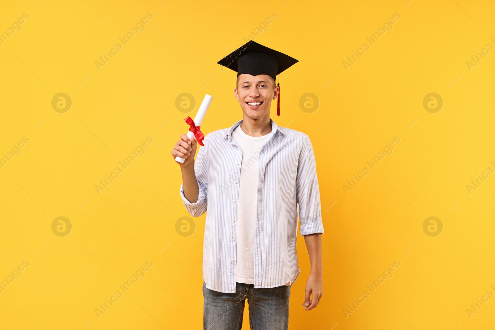 Photo of Happy student with diploma after graduation on orange background